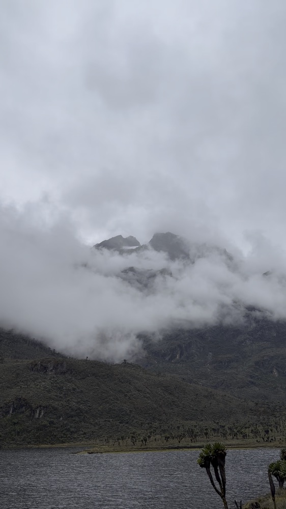 Mountain lake below cloud-covered slopes